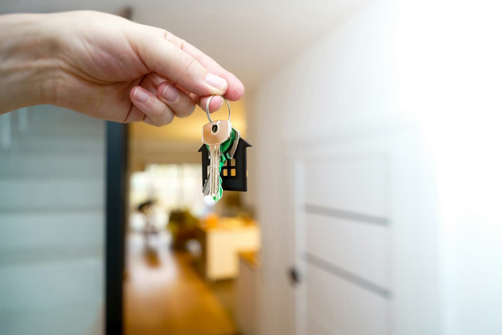 Makelaar overhandigt de huissleutels bij de voordeur